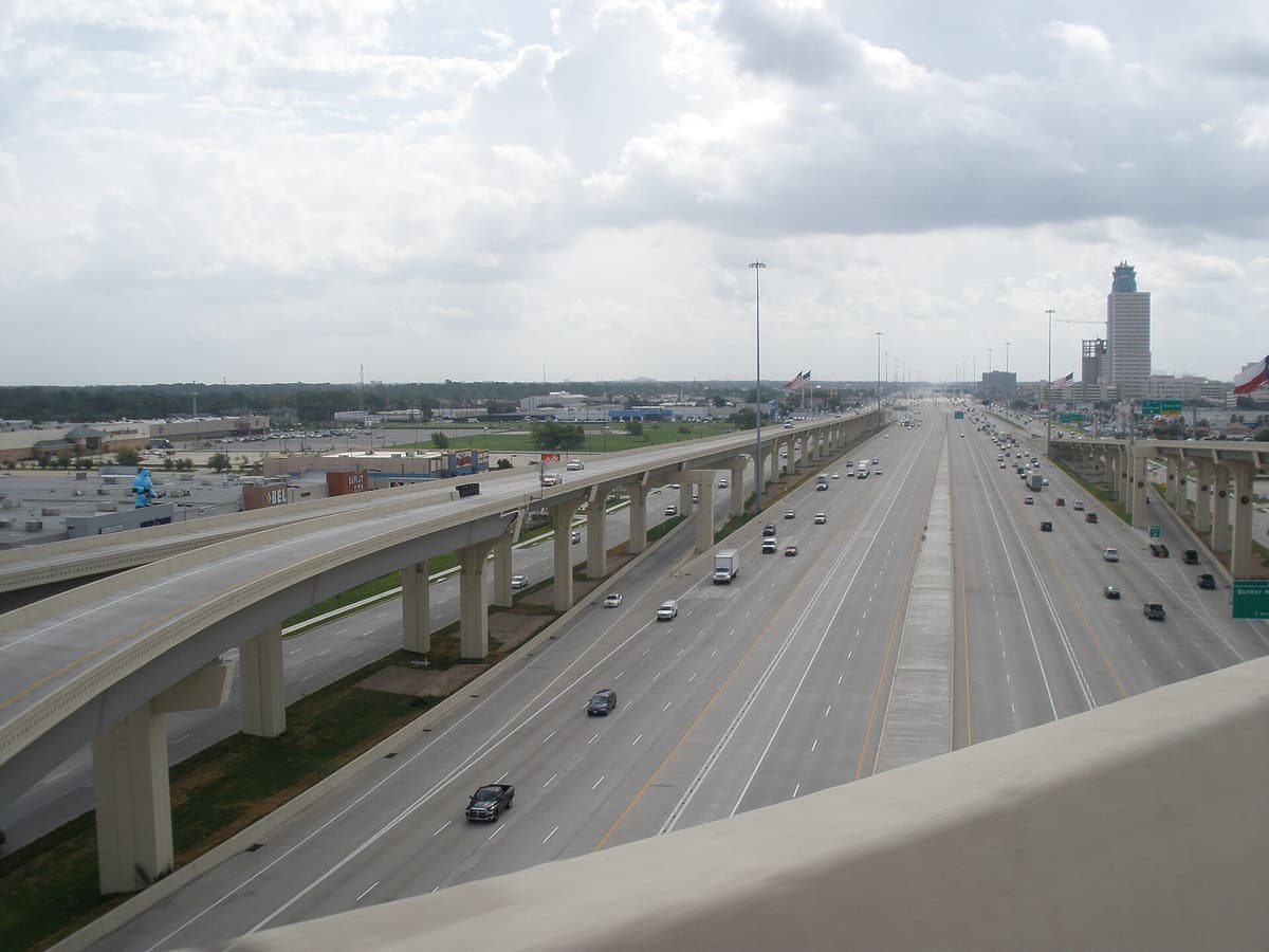 Wide Katy Freeway (I-10) in west Houston looking east from a Beltway 8 connector ramp near Gessner, with many lanes and central managed lanes