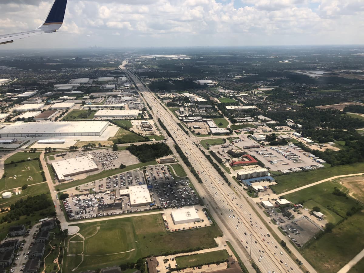 Aerial view looking south along Interstate 45 on Houston's north side, with frontage roads, big-box stores and warehouses beside the freeway